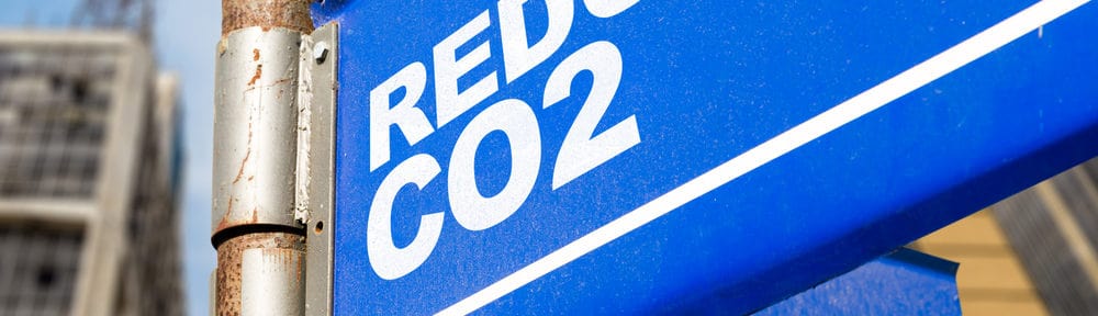 A blue sign with white writing saying Reduce co2