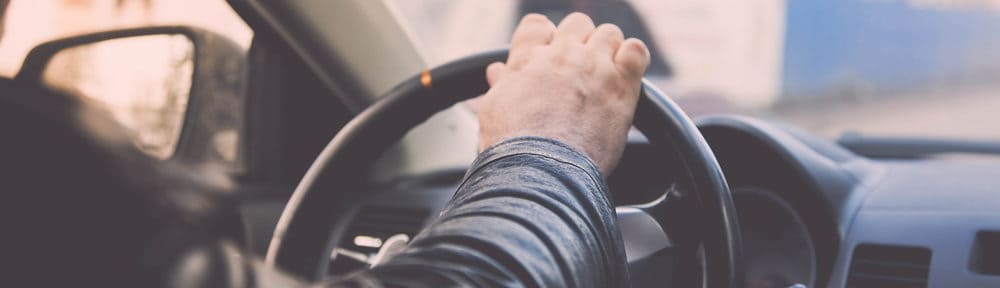 man driving a van is holding the steering wheel