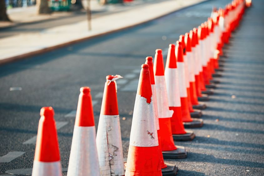 Row of orange traffic cones along the side of a road