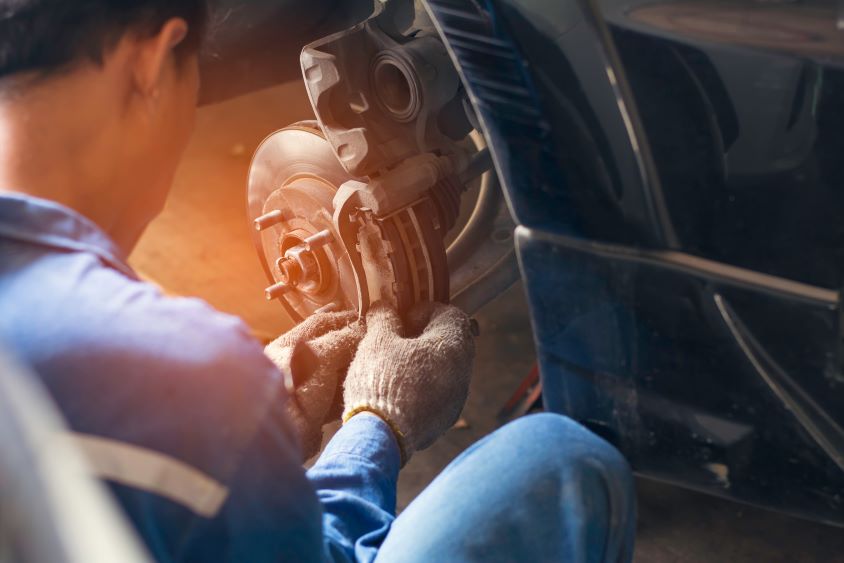 Male mechanic servicing the disc brake on a car