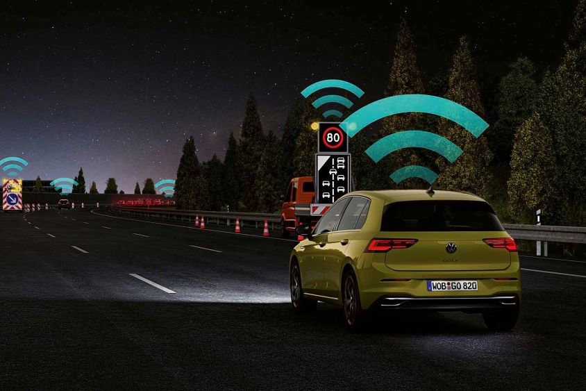 Car driving at night with wifi graphics indicating connectivity