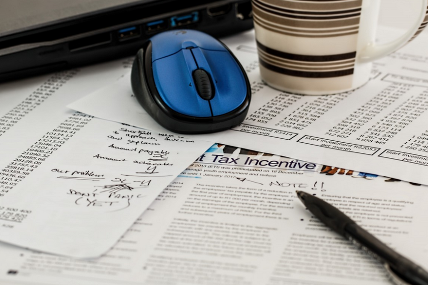 Blue mouse on top of receipts, pen to calculate taxes