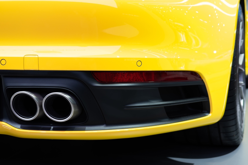 Duel exhaust pipes on the back of a yellow sports car