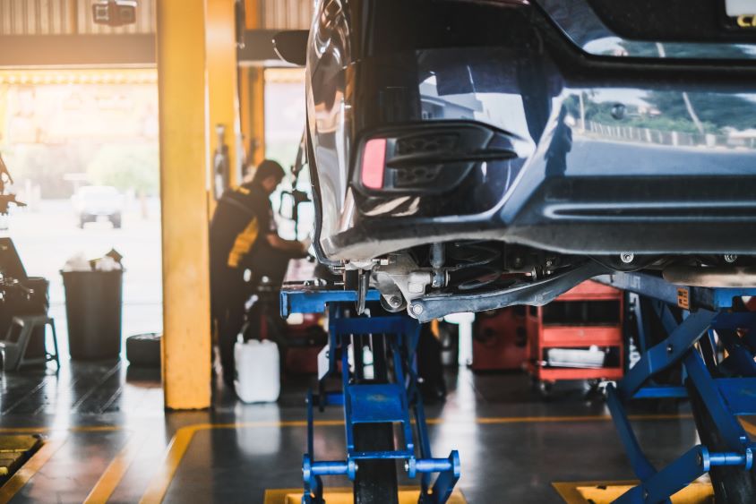 Car on car lift being serviced by mechanic