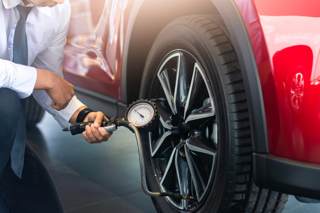 man checking tyre pressure