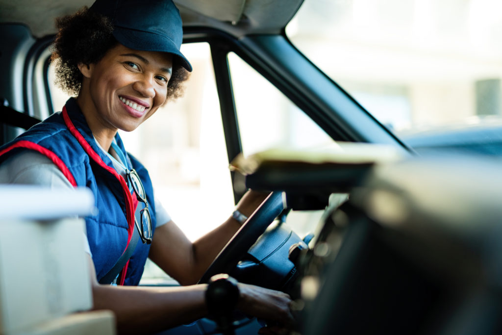 Image of a female courier in the driver's seat of a vehicle