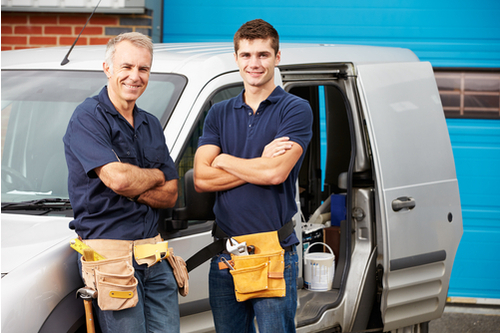 Two work men standing next to a van filled with tools