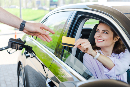 Woman sat in car using fuel card