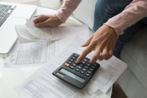 Close-up image of a man with receipts and a calculator