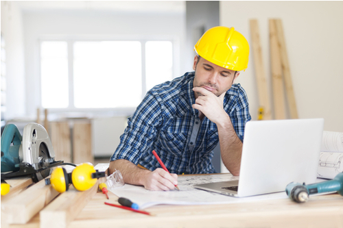 Construction worker sat at computer