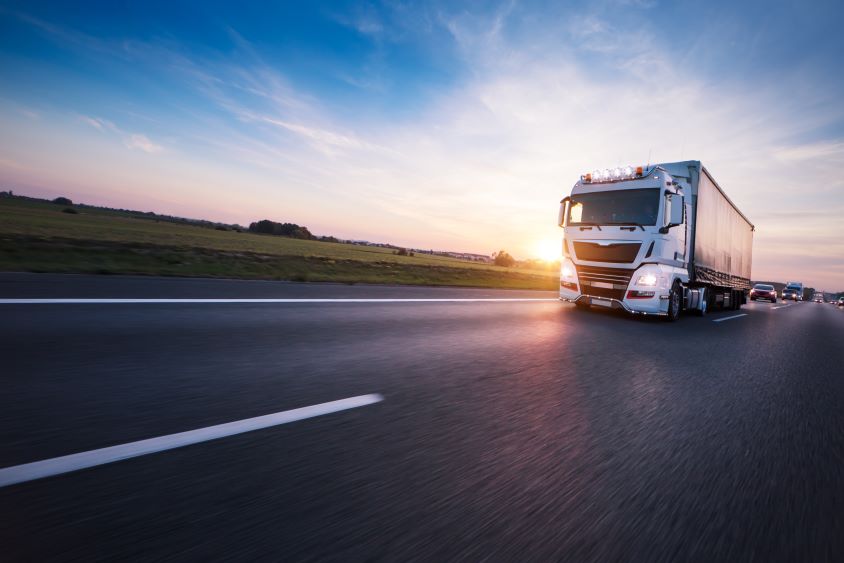 Lorry driving along European highway at sunset