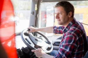 Truck driver driving in cab of semi-truck