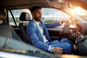 Man in suit behind the wheel of a car