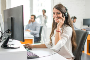 Customer service agent with headset at computer