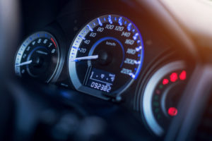 Closeup of car dashboard showing dials and odometer.