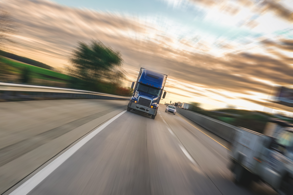 Big 18 wheeler semi truck on highway with motion blur