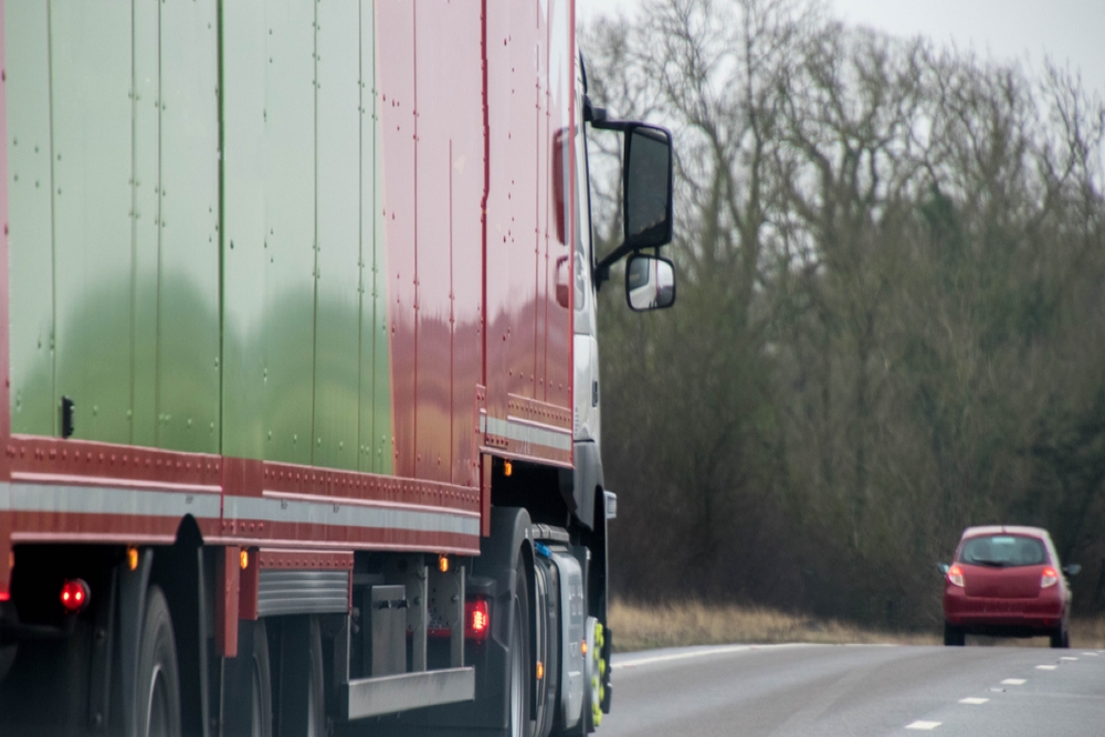 A large HGV travels across country to deliver or collect goods for the next business location