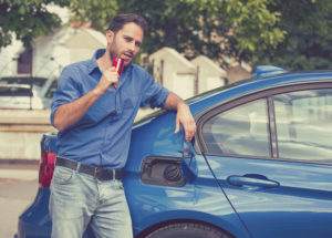 man with credit card opening fuel tank of his new car