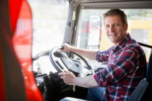 Male HGV driver smiling in the vehicle cabin