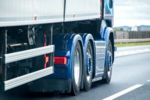 Blue lorry driving along road