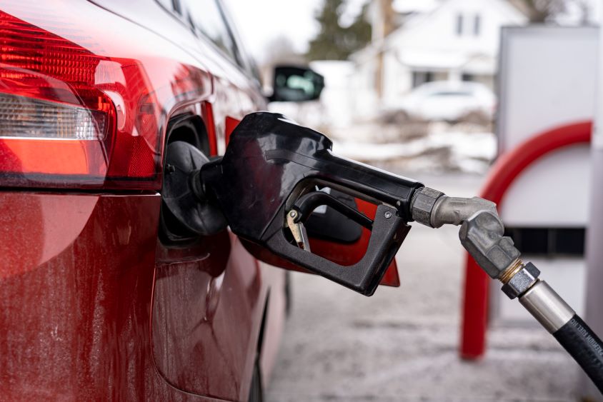 Red car with black fuel nozzle inserted