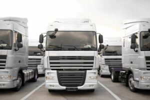 Row of white HGVs in a parking bay