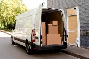 Delivery van with open back doors showing cardboard boxes