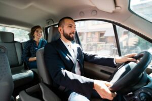 Smiling taxi driver talking to passenger