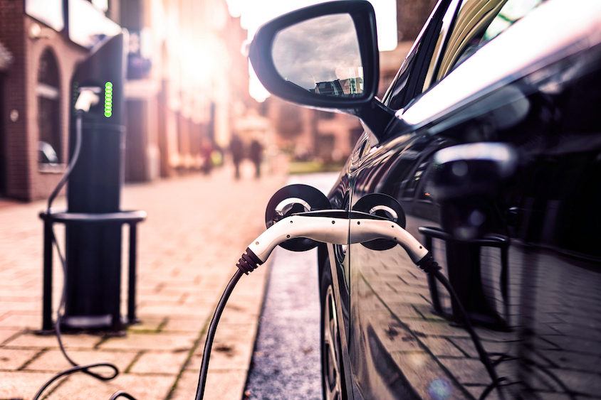Charger plugged in to a black electric vehicle