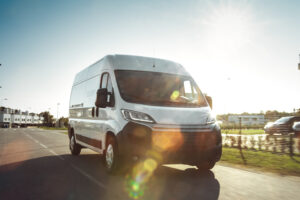 White van on road with lens flare 