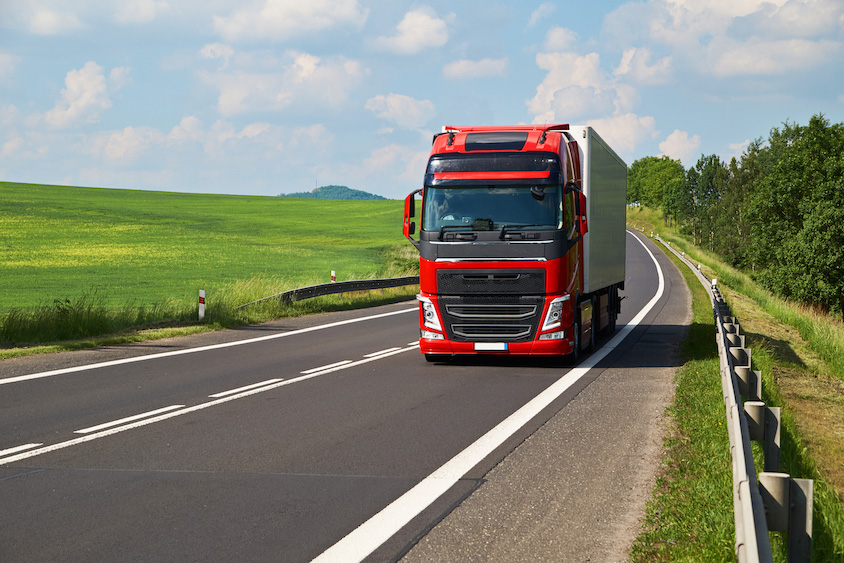 Red lorry on country road