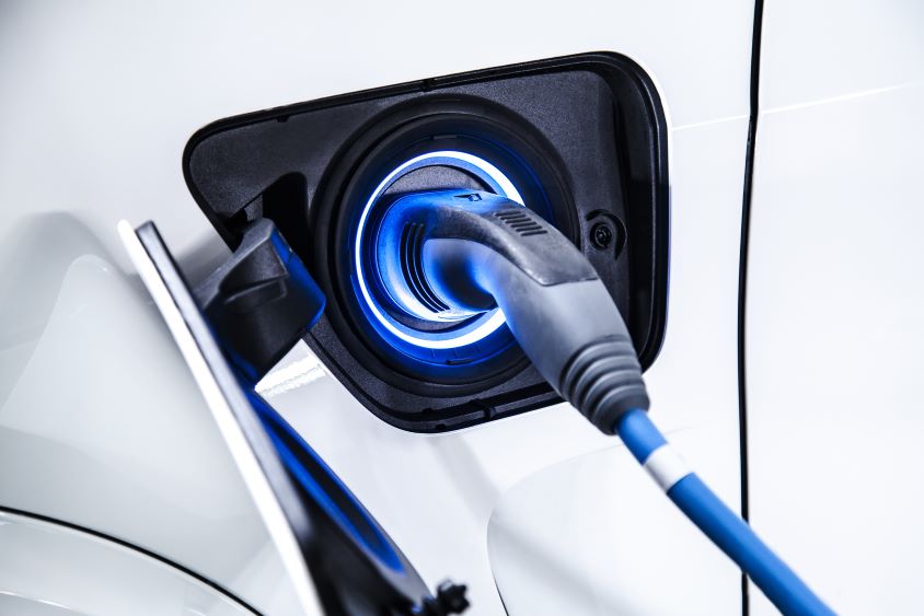 Electric charger plugged into white car