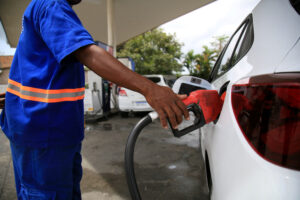 Petrol station attendant filling up car 