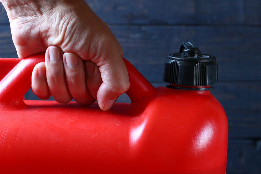 hand holding a plastic fuel container