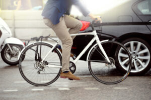 Cyclist riding alongside car and motorbike