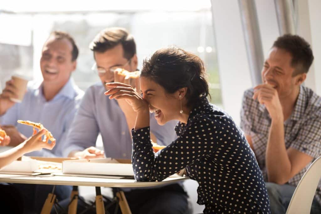 Group of co-workers laughing around a table